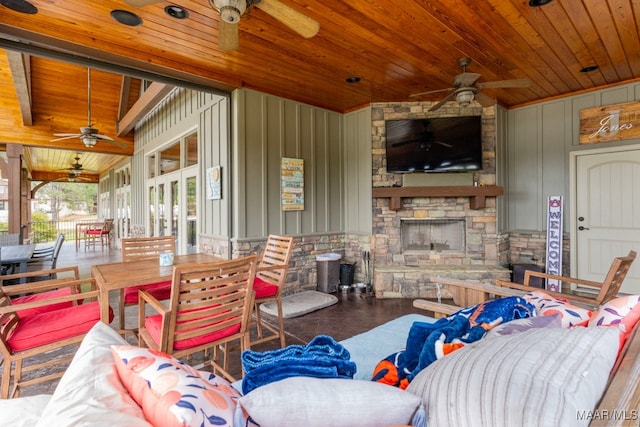 interior space with ceiling fan, outdoor dining area, and an outdoor stone fireplace