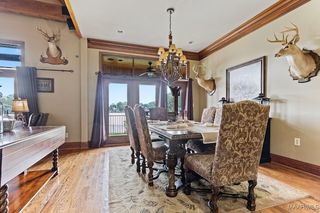 dining area with light wood-type flooring, baseboards, a chandelier, and crown molding