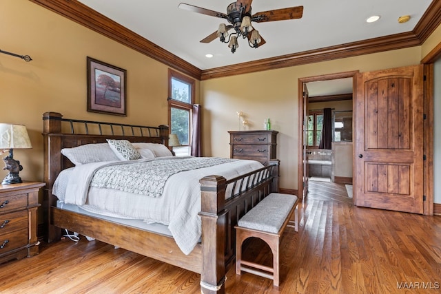 bedroom featuring baseboards, ceiling fan, ornamental molding, wood finished floors, and ensuite bathroom