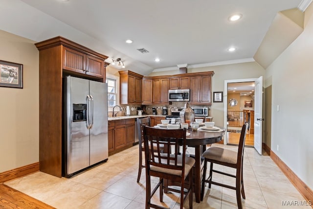 kitchen with stainless steel appliances, a sink, visible vents, light countertops, and backsplash