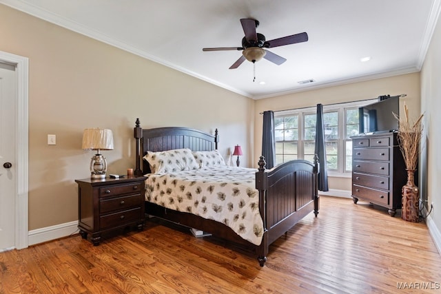 bedroom featuring wood finished floors, a ceiling fan, baseboards, visible vents, and crown molding