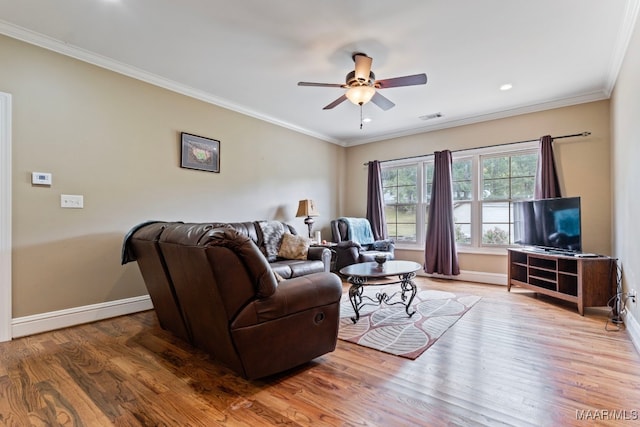 living room with visible vents, wood finished floors, baseboards, and ornamental molding