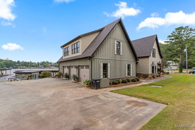 view of home's exterior featuring a garage, a shingled roof, driveway, a lawn, and board and batten siding