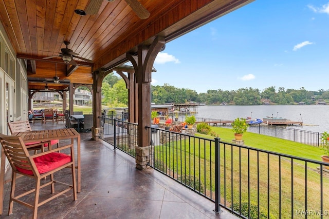 view of patio with a water view and ceiling fan