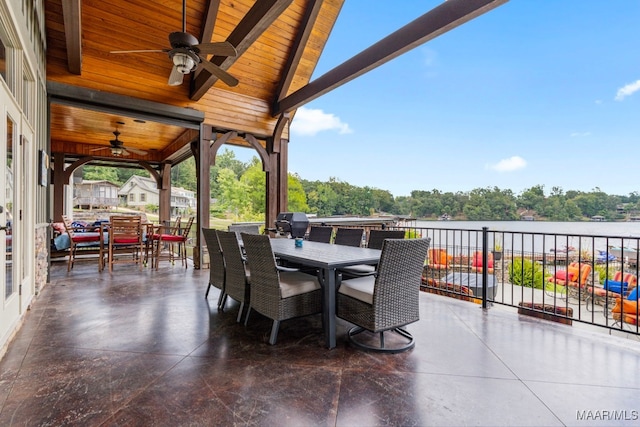 view of patio / terrace featuring a water view, ceiling fan, outdoor dining area, and area for grilling