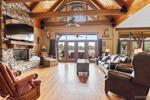 living area featuring wood ceiling, a fireplace, beam ceiling, and french doors