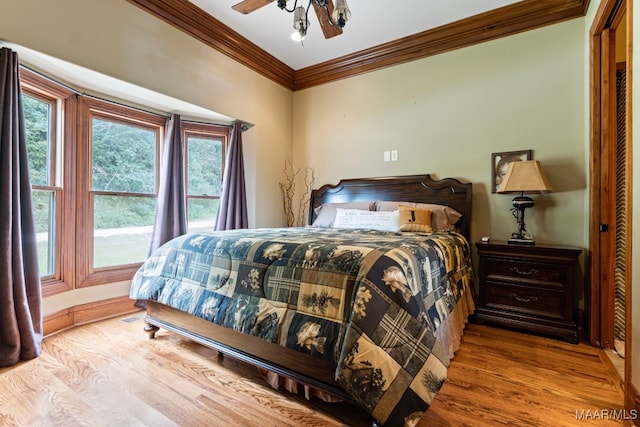 bedroom featuring light wood-type flooring, crown molding, and ceiling fan