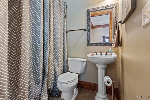 bathroom with curtained shower, tile patterned flooring, toilet, and baseboards