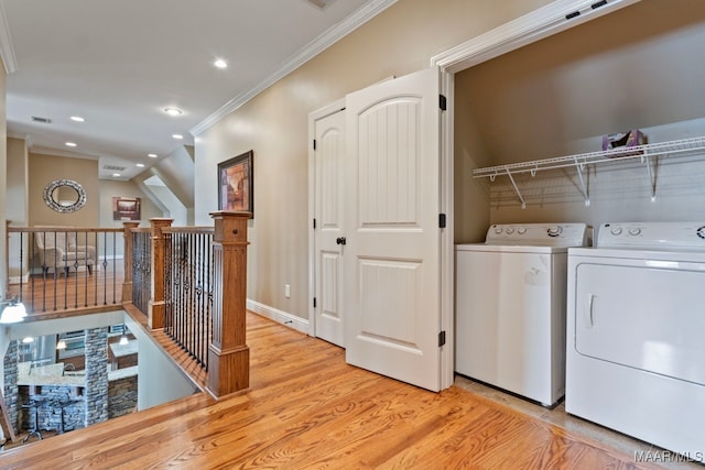 washroom featuring light wood finished floors, laundry area, recessed lighting, ornamental molding, and washer and clothes dryer