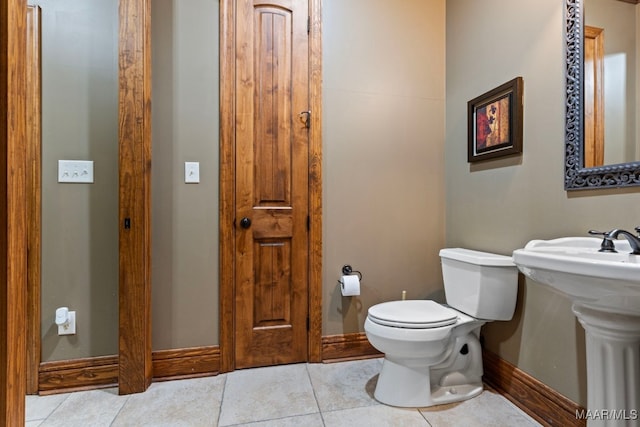 bathroom featuring tile patterned flooring, toilet, and baseboards