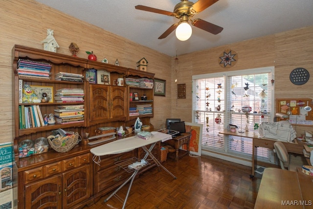 home office featuring a textured ceiling, dark parquet flooring, and ceiling fan