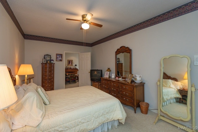 carpeted bedroom with ceiling fan and ornamental molding