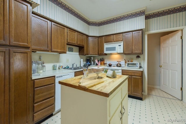 kitchen featuring white appliances, a kitchen island, and wooden counters