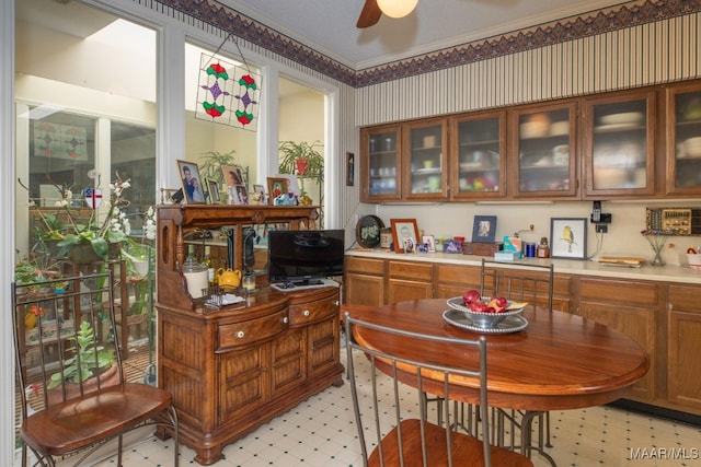 bar with light floors, wallpapered walls, ornamental molding, and a ceiling fan