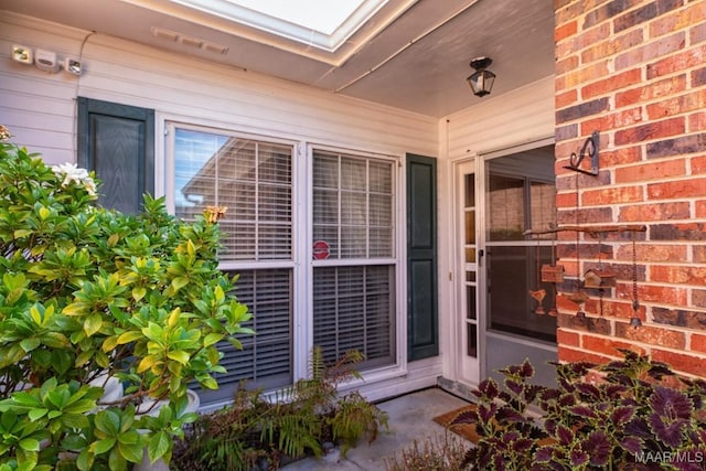 doorway to property featuring brick siding