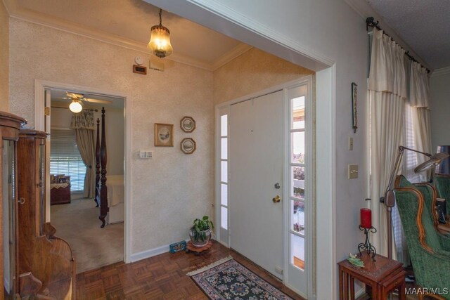 foyer featuring ornamental molding, dark parquet floors, and ceiling fan