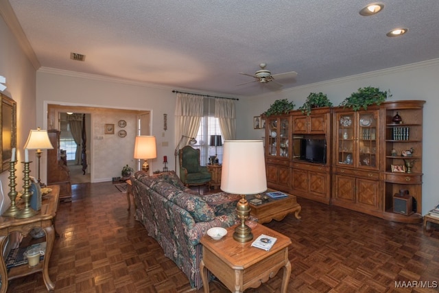 living room featuring visible vents, ornamental molding, ceiling fan, a textured ceiling, and baseboards