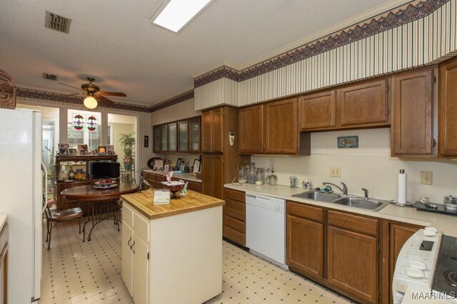 kitchen with white appliances, a textured ceiling, wood counters, sink, and ceiling fan