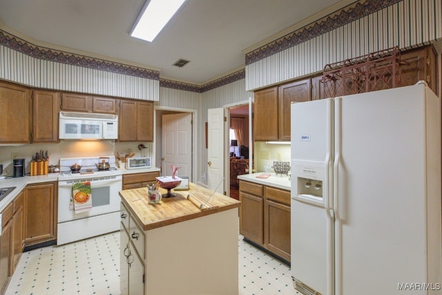 kitchen featuring light floors, white appliances, butcher block counters, and wallpapered walls