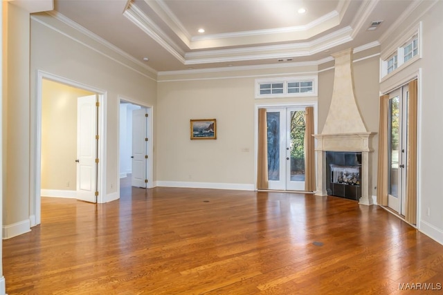 unfurnished living room featuring french doors, plenty of natural light, crown molding, and hardwood / wood-style floors