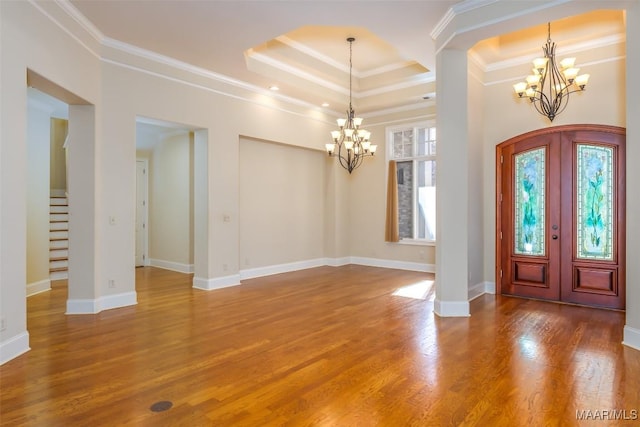 entryway with french doors, ornamental molding, a raised ceiling, a chandelier, and hardwood / wood-style floors