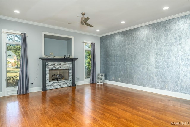 unfurnished living room with ornamental molding, a healthy amount of sunlight, and hardwood / wood-style flooring