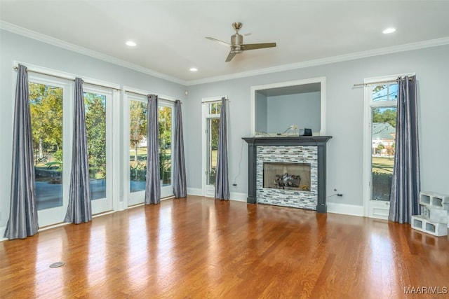 unfurnished living room featuring a fireplace, hardwood / wood-style floors, ceiling fan, and ornamental molding