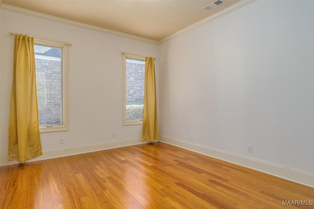 empty room featuring crown molding and light hardwood / wood-style flooring