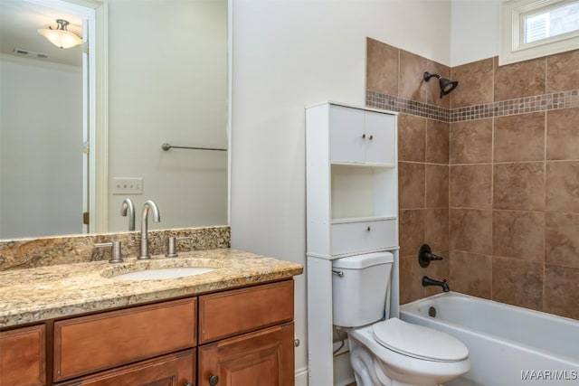 full bathroom with vanity, tiled shower / bath combo, and toilet