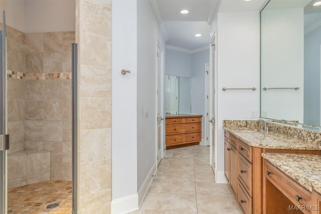 bathroom featuring a tile shower, tile patterned floors, vanity, and ornamental molding