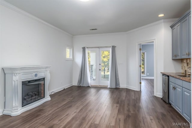 unfurnished living room with french doors, crown molding, sink, and dark hardwood / wood-style floors