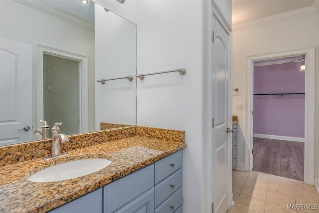 bathroom with tile patterned flooring, vanity, and crown molding