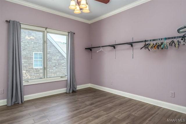 spare room featuring hardwood / wood-style floors, ornamental molding, and a notable chandelier