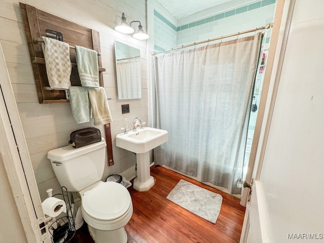 bathroom featuring toilet, a shower with curtain, and hardwood / wood-style floors