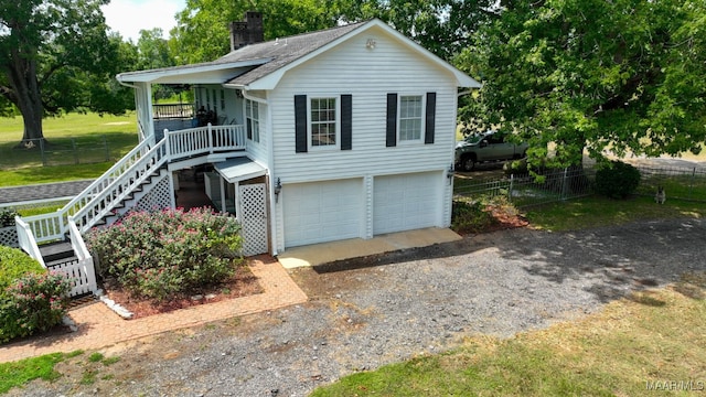 view of front of property featuring a garage, a front yard, and covered porch