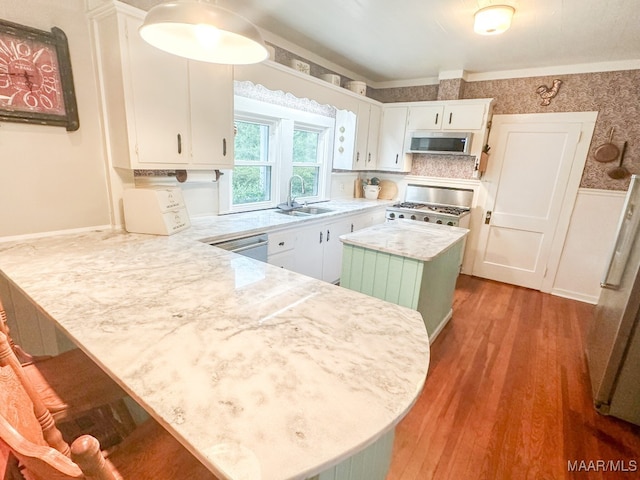 kitchen featuring white cabinetry, a breakfast bar area, stainless steel appliances, and light hardwood / wood-style floors