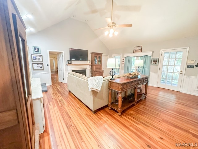 living room with high vaulted ceiling, light hardwood / wood-style flooring, and ceiling fan