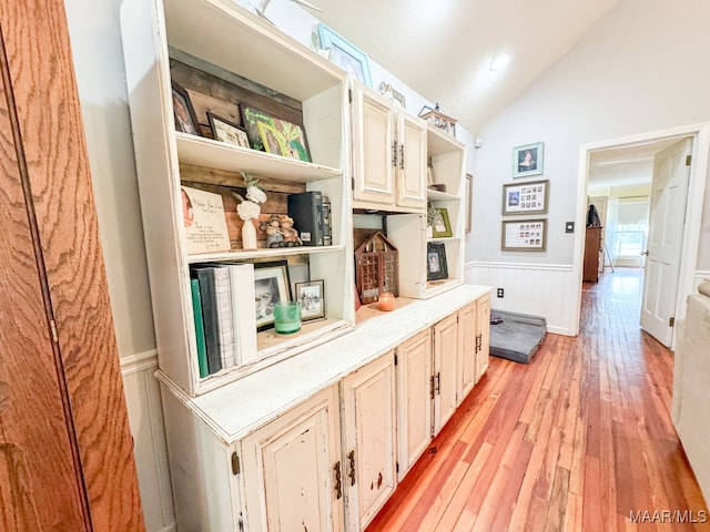 hallway featuring lofted ceiling and light hardwood / wood-style flooring