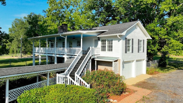 view of front of property with a garage, a porch, and ceiling fan