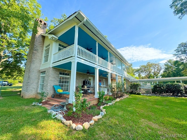 rear view of house featuring a yard and a balcony