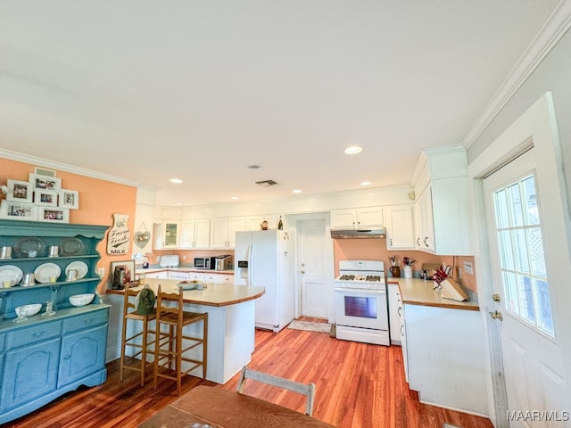 kitchen with a breakfast bar area, white appliances, light hardwood / wood-style flooring, ornamental molding, and white cabinetry