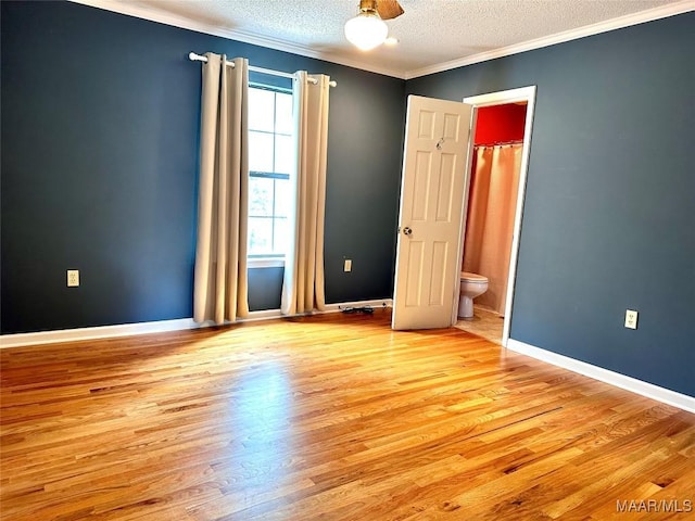 unfurnished room with baseboards, light wood-style flooring, ornamental molding, and a textured ceiling