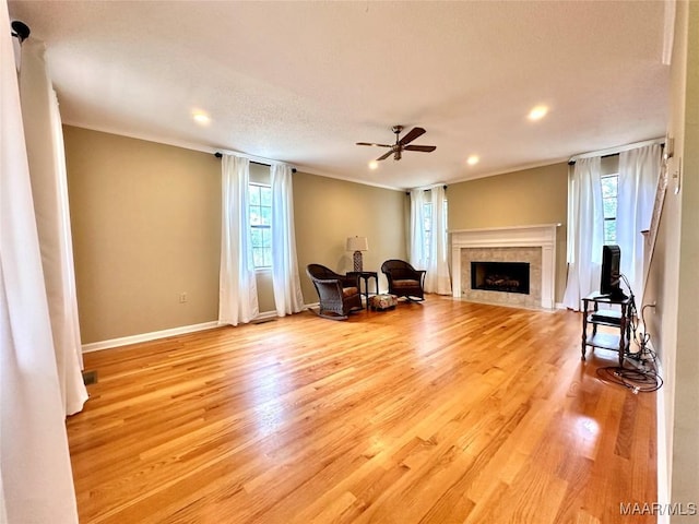 living area featuring crown molding, light wood-type flooring, and plenty of natural light