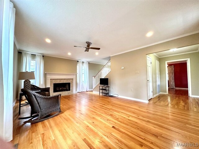 living room with wood finished floors, a fireplace, and stairs