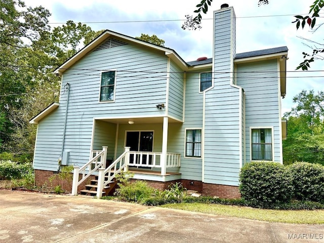 view of front facade with crawl space and a chimney