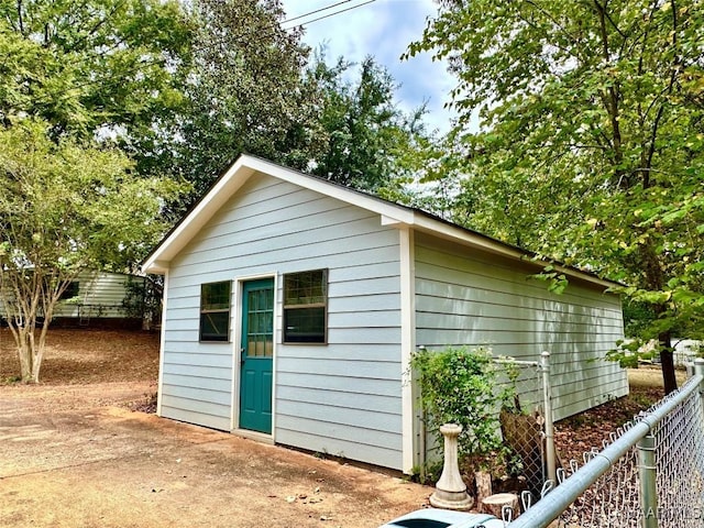 view of outbuilding with fence and an outbuilding