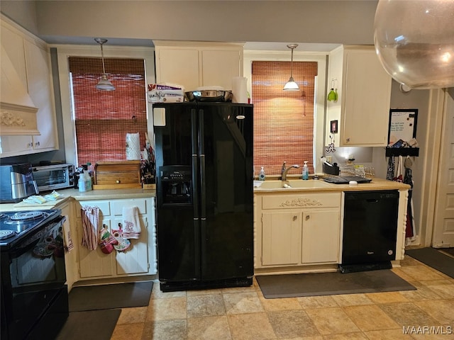 kitchen featuring black appliances, pendant lighting, and sink