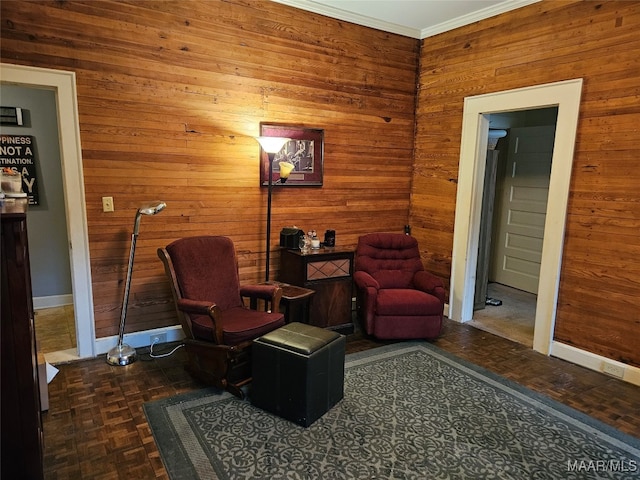 living area with crown molding and wood walls