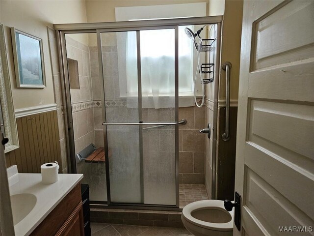 bathroom with tile patterned flooring, toilet, a shower with door, and vanity