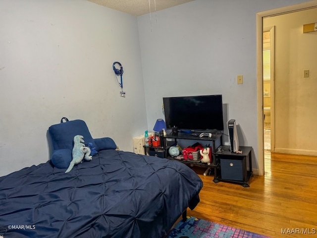 bedroom featuring a textured ceiling and wood-type flooring